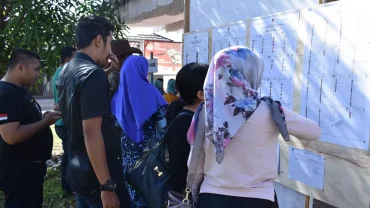 Para pemilih sedang mencermati Daftar Calon Tetap (DCT) sebelum memberikan suara dalam Pemilu &copy; mwahyunz.id